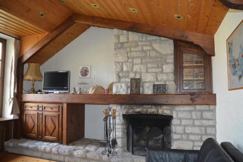 a living room with a stone fireplace with a tv at Gutshaus Wilhelmsruh in Möhnesee