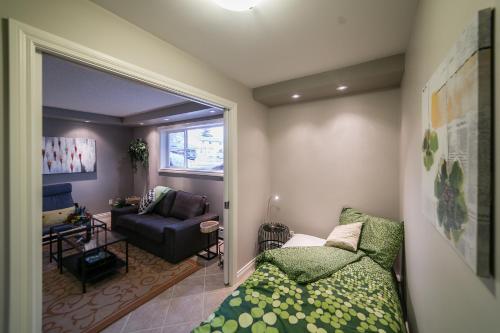 1 dormitorio con 1 cama y sala de estar con sofá en Mckinnon Pointe #104, en Edmonton