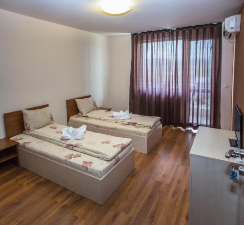 a room with two beds and a television in it at Hotel West in Blagoevgrad