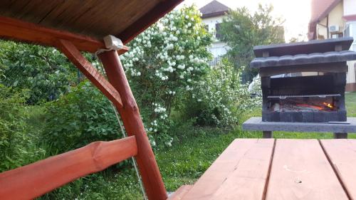 a fireplace in a yard with a wooden table and a bench at Arina Villa in Hévíz