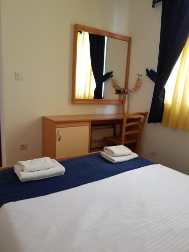 a bedroom with a white bed and a mirror at Apartments Tamara in Budva