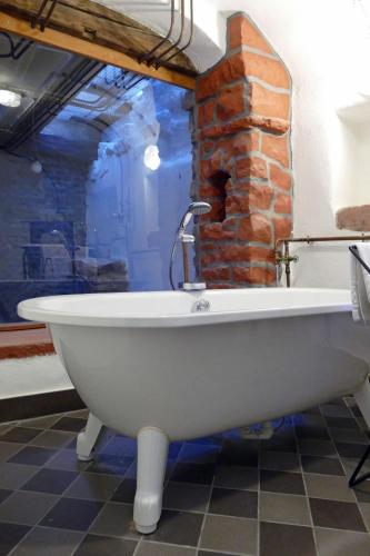 a white bath tub in a room with a brick wall at Fachwerkhaus Maximilian in Speyer