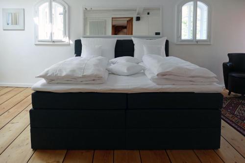 een bed met witte lakens en kussens in een slaapkamer bij Fachwerkhaus Maximilian in Speyer