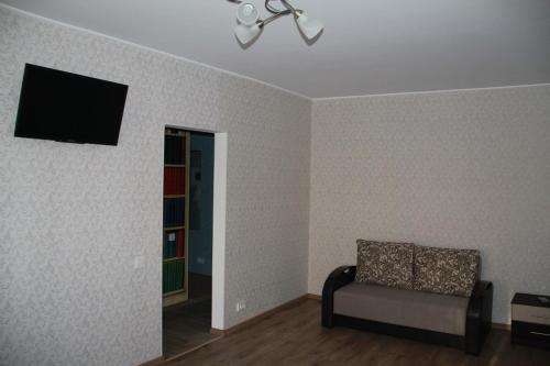 a living room with a chair and a flat screen tv at Современная 1-комнатная квартира in Kharkiv