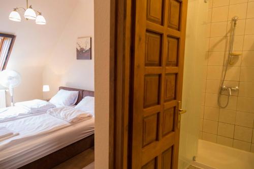 drzwi do sypialni z łóżkiem i prysznicem w obiekcie Arina Villa w Hévízie