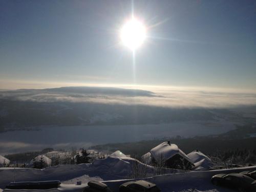 a view of the sun over a lake in the snow at Norefjell Panorama in Noresund