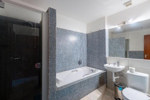 a bathroom with a tub and a sink and a toilet at Modern apartment few steps from centre in Prague