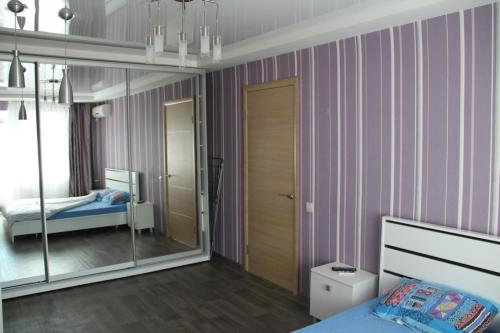 a bedroom with a bed and a mirror in it at Современная 1-комнатная квартира in Kharkiv