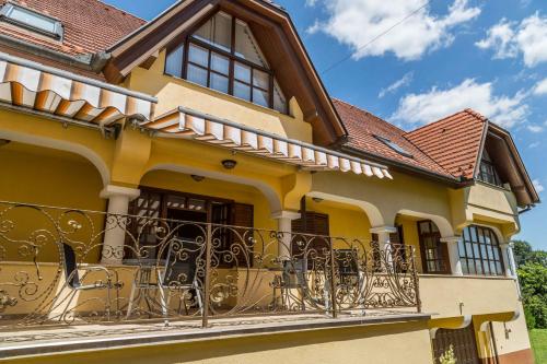 a yellow house with a balcony at Arina Villa in Hévíz