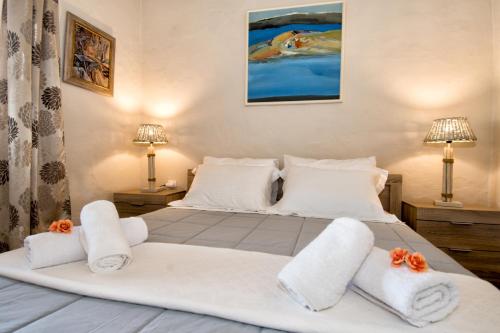 um quarto com uma cama com toalhas e 2 candeeiros em The Veranda of Gavrion-Exclusive, Centrally located with Seaview em Gavrio