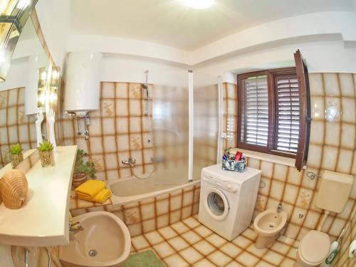 a bathroom with a shower and a washing machine at Apartments K & K Dubrovnik in Dubrovnik