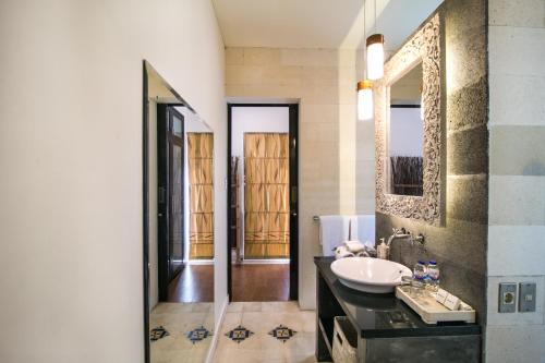 a bathroom with a sink and a mirror at Sunset Paradise at Temple Hill Jimbaran in Jimbaran