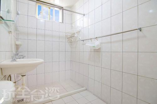 馬公市にあるシァン ティン ホームステイの白いタイル張りのバスルーム(洗面台、トイレ付)