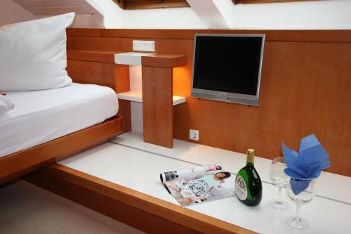 a bedroom with a bed and a tv and wine glasses at Hanseat in Helgoland