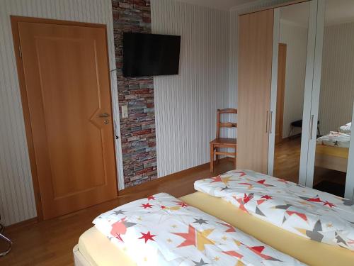 two beds in a room with a television on a wall at Benkelberg in Sitzerath