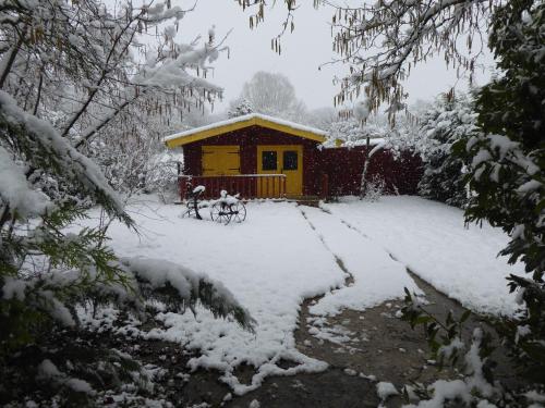 two people on bikes in front of a cabin in the snow at Chalet aux pied des vignes in Montigny