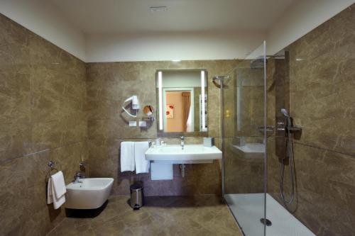 a bathroom with a tub, toilet and sink at Hotel Palazzo San Lorenzo & Spa in Colle di Val d'Elsa
