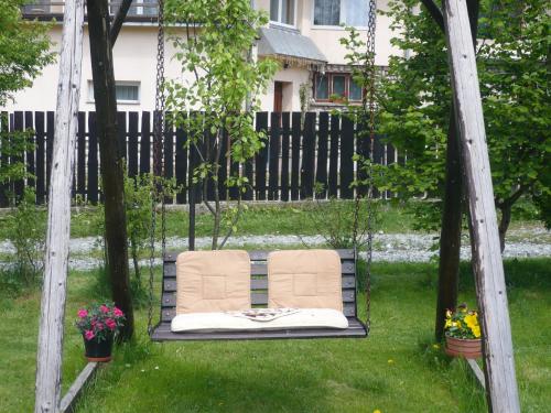 a chair sitting on a swing in a yard at Pokoje gościnne w górach in Kościelisko