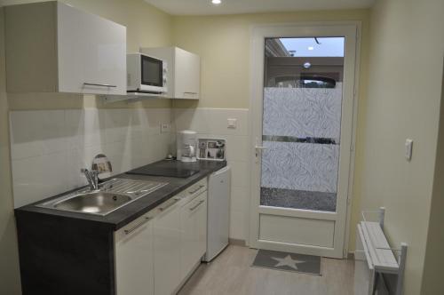 une petite cuisine avec un évier et une fenêtre dans l'établissement Studio indépendant le Mahana, à Magalas