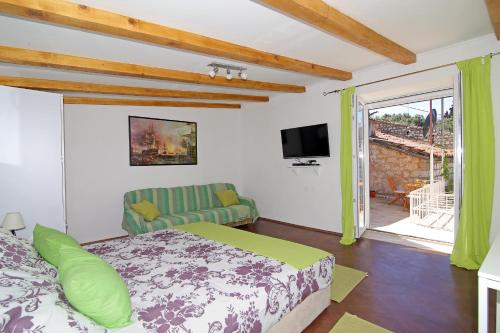 1 dormitorio con cama, sofá y TV en Apartments Solitudo, en Dubrovnik