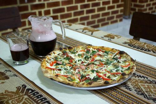 uma pizza sentada numa mesa ao lado de uma bebida em B&B Valcava em Urubamba