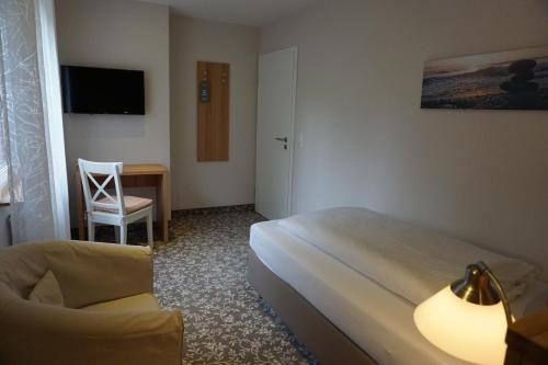 a hotel room with a bed and a chair and a desk at Mansion in Bad Arolsen