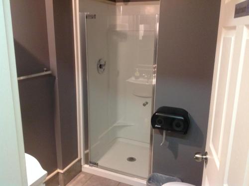 a shower with a glass door in a bathroom at Algonquin Hotel in Sault Ste. Marie