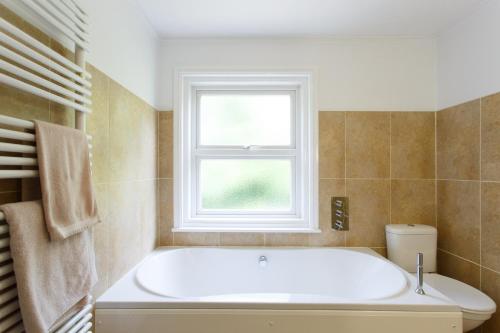 a white bath tub in a bathroom with a window at Executive Victorian House in Andover
