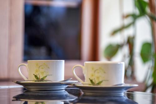 two cups and saucers sitting on a table at NeriesApartment No.1 Holidays By J. Basanaviciaus in Palanga