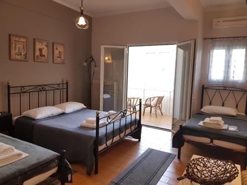 a bedroom with two beds and a balcony at Exarchos Guest House in Ioannina