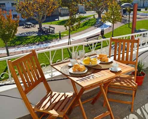 a wooden table with plates of food on a balcony at Alojamento Charme in Bombarral