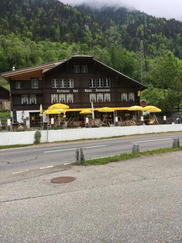 a building with yellow umbrellas in front of it at "Terrasse" Nessental in Gadmen