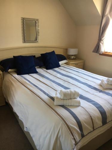 a bedroom with a large bed with towels on it at Cairngorm Mountain View in Aviemore