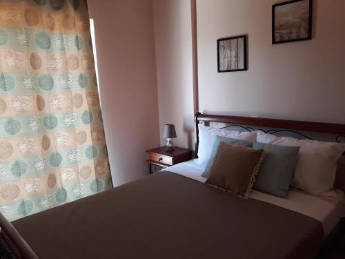 a bedroom with a bed with a curtain and a window at Villa Oneiro in Kanali