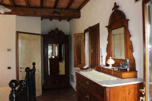 een badkamer met een houten wastafel en een spiegel bij Camere Alabastro Fontesettimena in Volterra