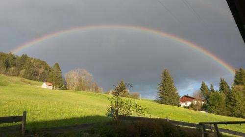 a rainbow in the sky over a green field at Jungholz Erlebnis in Jungholz
