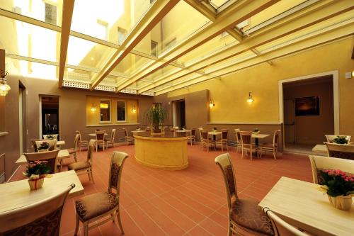 a restaurant with tables and chairs in a room at Hotel Palazzo San Lorenzo & Spa in Colle Val D'Elsa