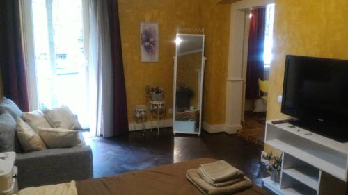 a living room with a couch and a flat screen tv at Vasilis apartment in Tbilisi City