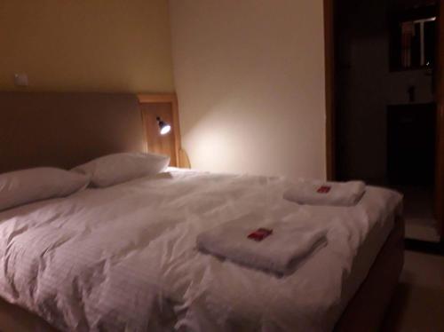 a bedroom with a white bed with towels on it at Mekelle Hotel in Mekʼelē