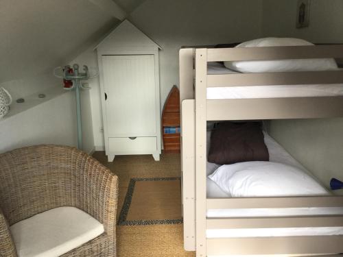 - une chambre avec 2 lits superposés et une chaise dans l'établissement Maison de pêcheur, à Cancale