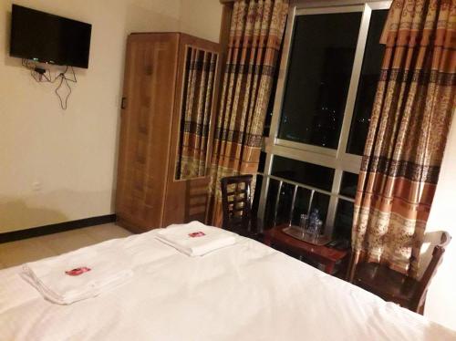 a bedroom with a white bed and a window at Mekelle Hotel in Mekʼelē