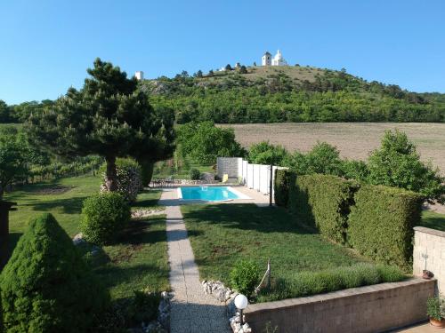 a garden with a swimming pool and a hill at Pod Svatým kopečkem in Mikulov