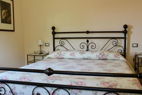 a bedroom with a bed with a floral bedspread at L'Antico Cipresso in Poppi