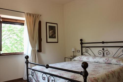 a bedroom with a bed and a window at L'Antico Cipresso in Poppi