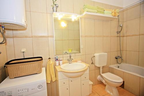 a bathroom with a sink and a toilet and a mirror at The View in Supetar