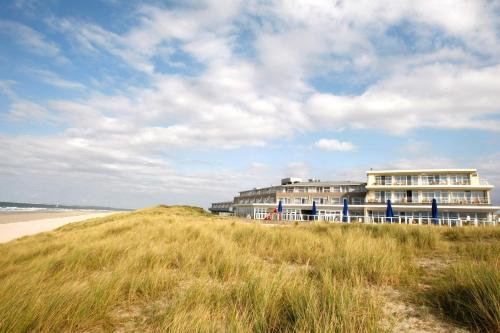 a building on top of a hill next to a beach at WestCord Strandhotel Seeduyn in Oost-Vlieland