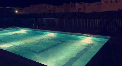 a large swimming pool lit up at night at Blansyah Resort - Families Only in Taif