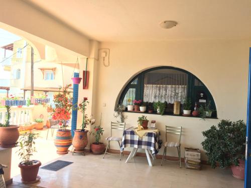 a patio with a table and chairs and potted plants at Alexia House in Neos Marmaras