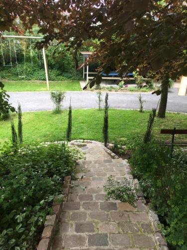 a stone path in a park with a bench at B&B Au bois dormant chambres d hotes in Tillé