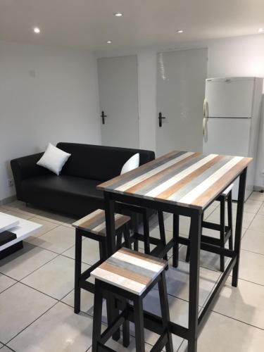 un salon avec une table et un canapé dans l'établissement Maisonnette climatisée, à Saint-Jean-de-Monts